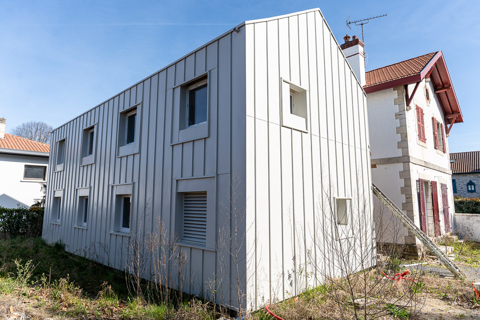 Extension de maison en bardage métallique clair, projet de rénovation